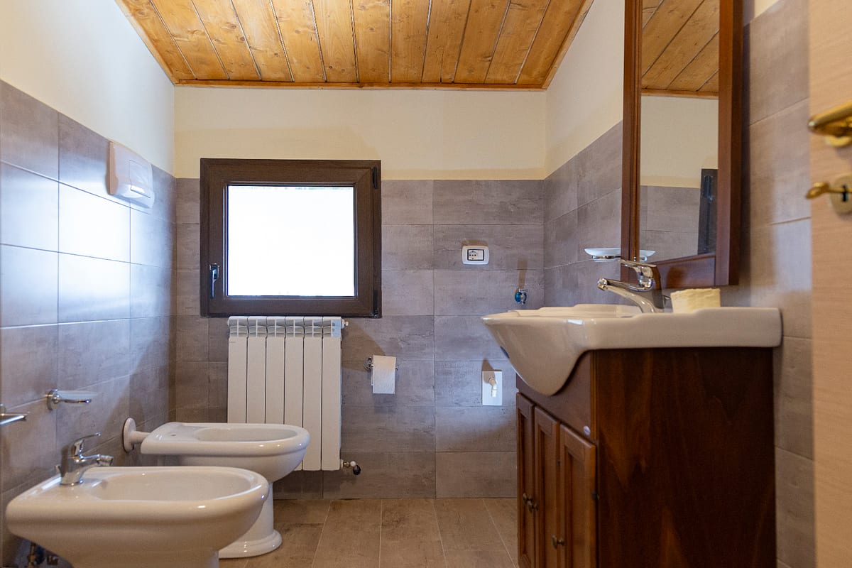 Bagno rustico con soffitto in legno